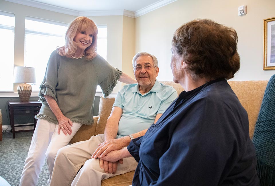 Three seniors enjoying a pleasant conversation in a living room.